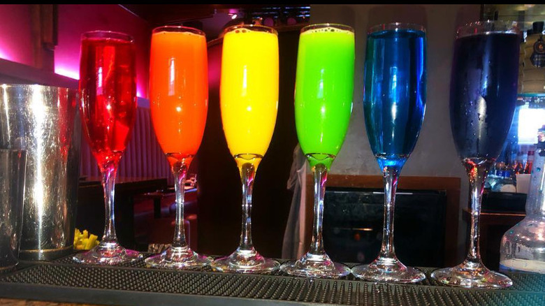 Rainbow colored cocktails in champagne flutes on the bar at Suzy Wong's