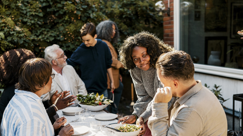 people laughing and smiling at dinner party
