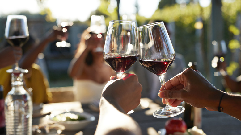 hands holding up drinks in evening light