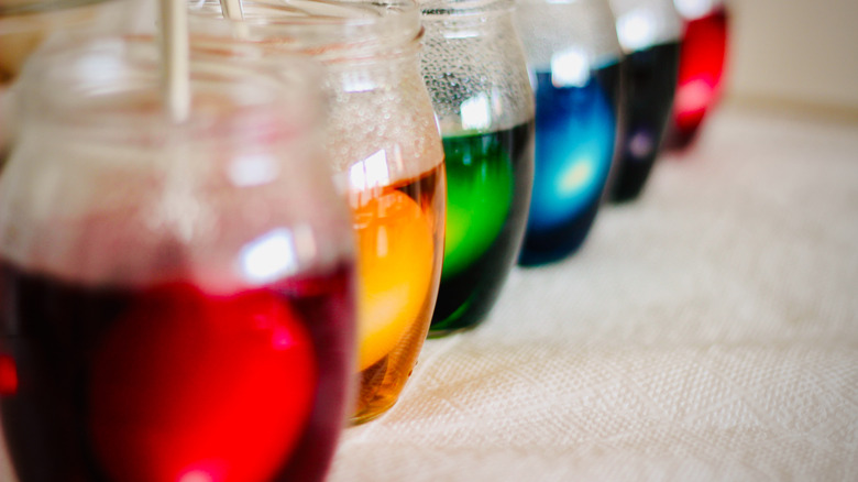 A line of glasses with different colored liquids