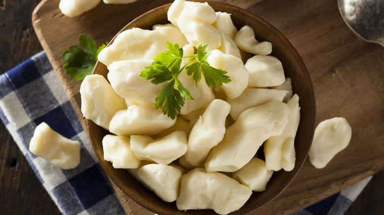 Wooden bowl filled with large cheese curds