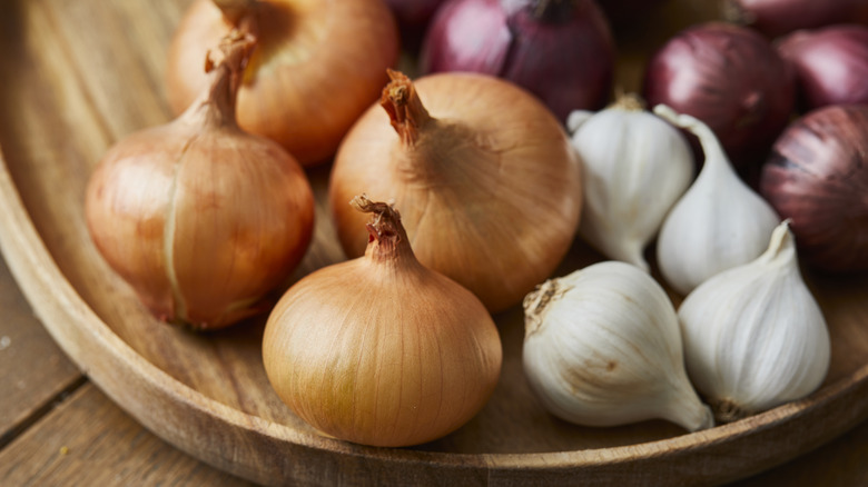 garlic and onions in a shallow wooden basket
