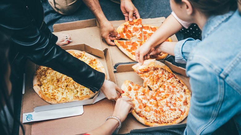 People eating pizzas with different sauces