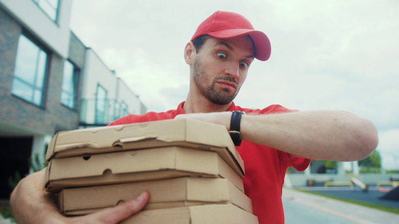 Pizza delivery person frustrated and checking watch