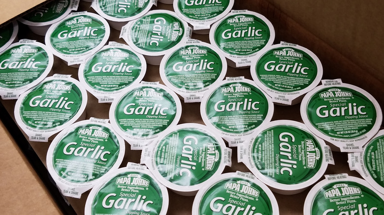 Box full of Papa John's garlic sauce containers