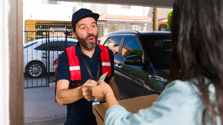 Woman tipping delivery person in cash