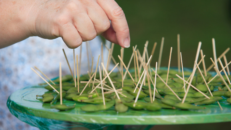 Someone selecting food samples from a platter