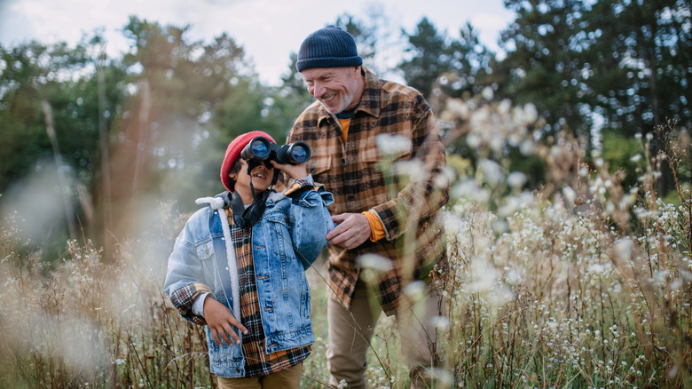 man and boy looking through binoculars
