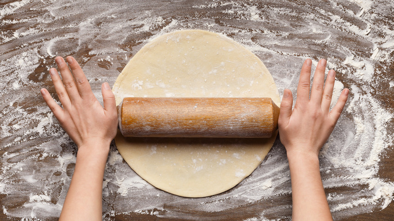 Person rolling out a pie crust