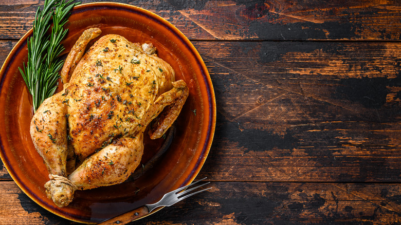 Whole roast chicken on a red platter
