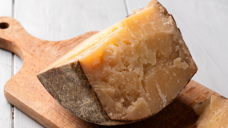 A wedge of Pecorino Fiore Sardo on a wooden board.