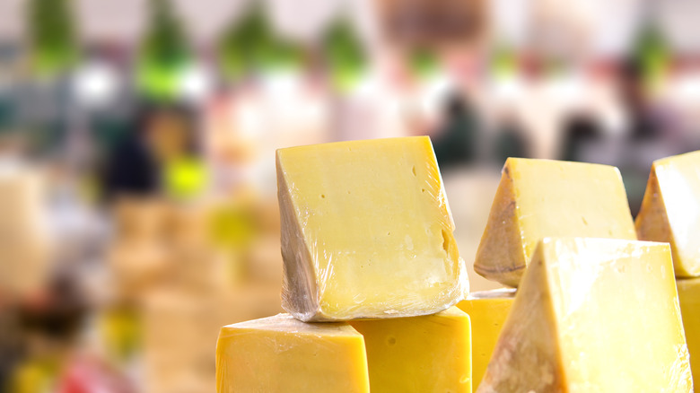 Wedges of an ivory-colored cheese wrapped in plastic wrap.