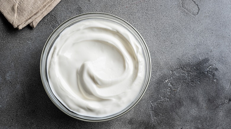 Bowl of sour cream on a gray surface