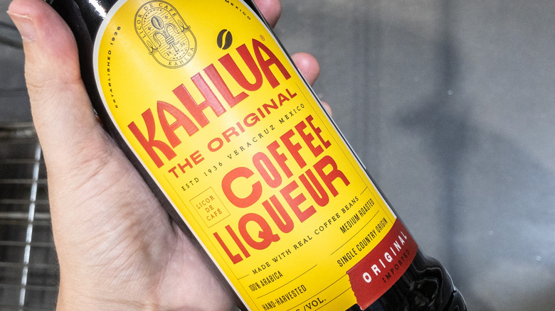 Bottle of Kahlúa in someone's hand