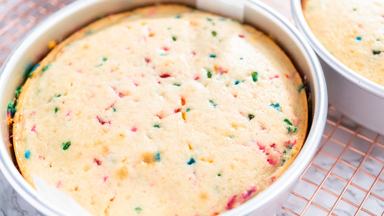 Funfetti cake in a cake pan on a wire rack