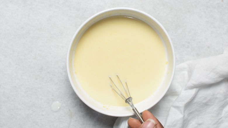 Pudding with whisk in a white bowl