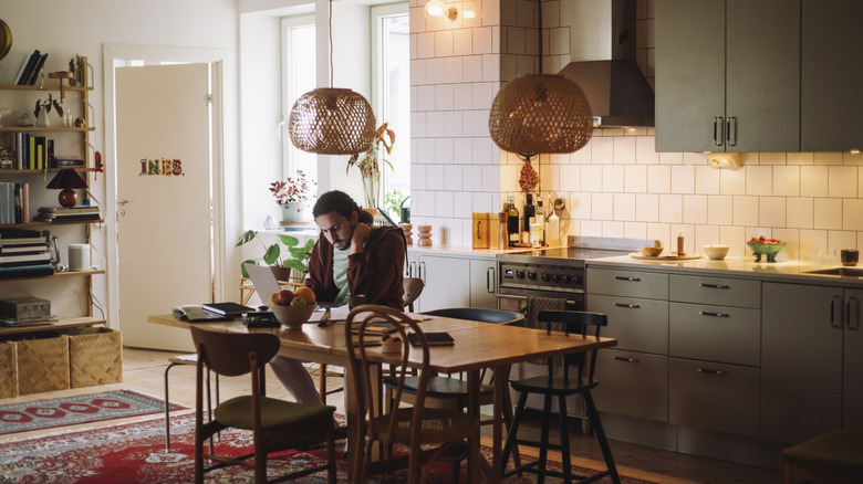 man sitting at kitchen table in modern boho home