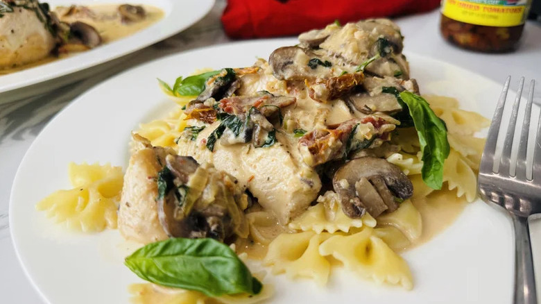 Creamy tuscan chicken atop farfalle pasta
