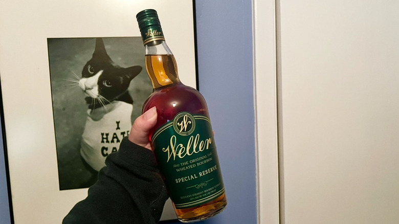 A hand holding a unopened bottle of Weller Special Reserve