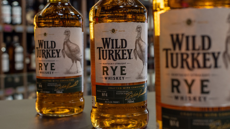 3 bottles of Wild Turkey Rye sit on a bar