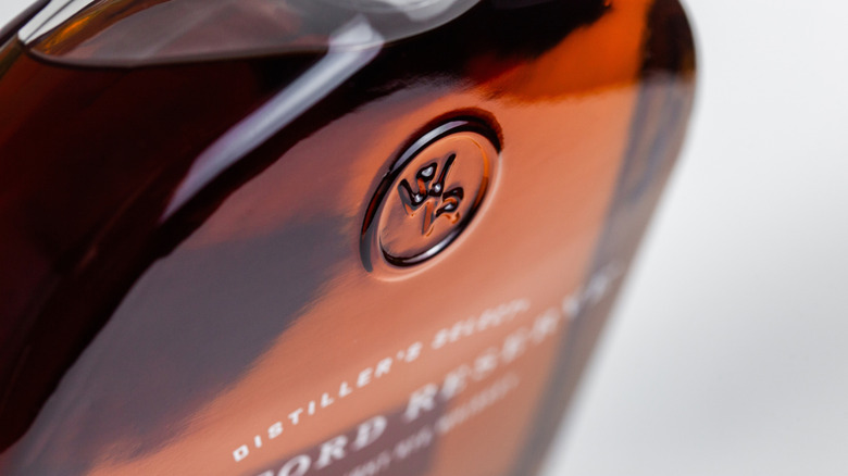 A close up of the WR logo on a glass bottle. WR is Woodford Reserve.