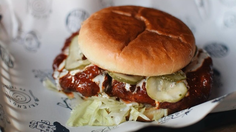 A glazed chicken sandwich with fresh lettuce and pickles from Farm Spirit at Blue Jay Brewing