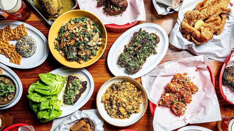 Several plates of food from Edmund's Oast, including chicharrones, salads, and skewers