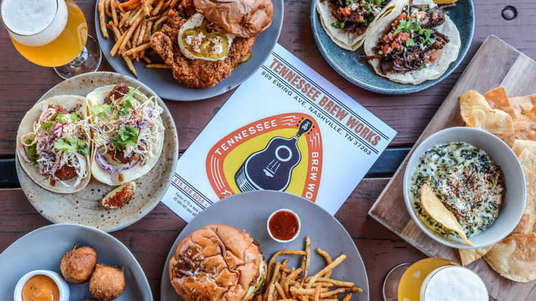 Several plates including tacos, fried chicken, and beer from Tennessee Brew Works
