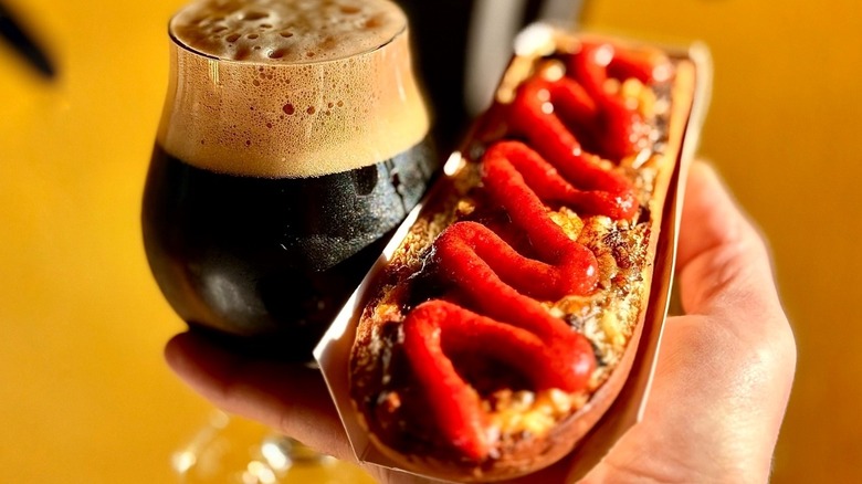 A Polish Zapiekanka alongside a frothy dark beer