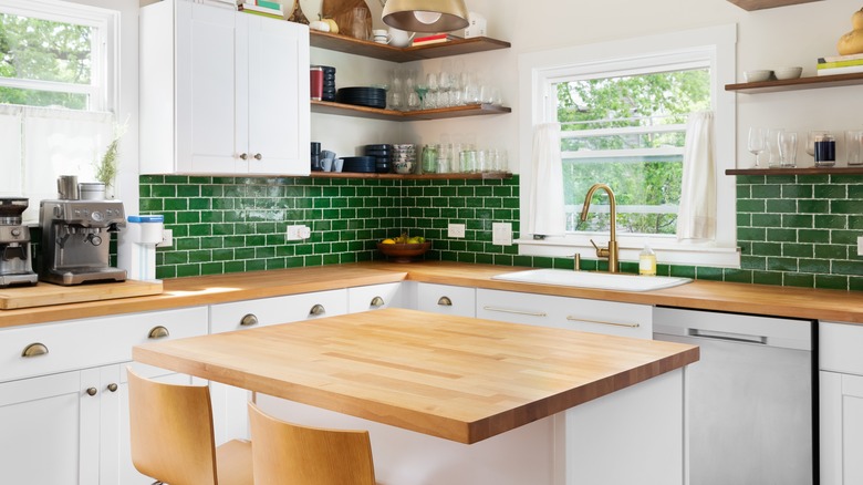 Butcher block countertop in a green kitchen