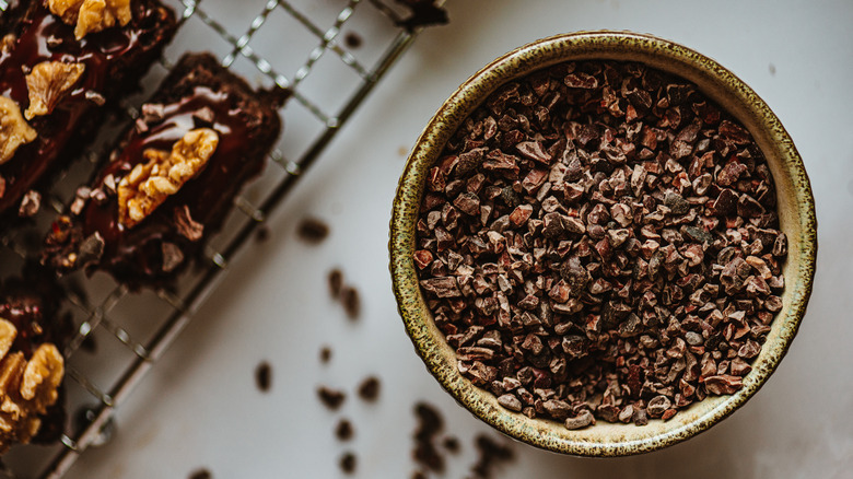 Cacao nibs in a bowl with baked goods