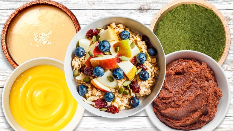 Overnight oats with four bowls of ingredients on white background