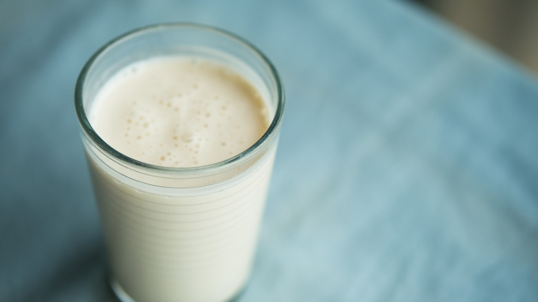Glass of kefir on blue background
