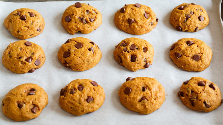 Pumpkin chocolate chip cookies on a baking sheet