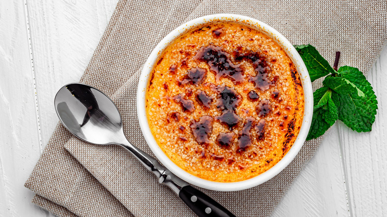 Crème brûlée dessert with mint leaves and spoon
