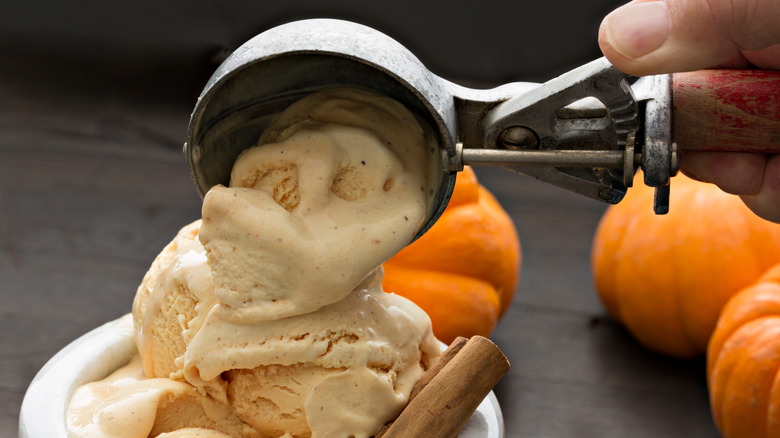 Scooping pumpkin ice cream with metal ice cream scoop