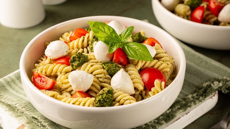 Bowl of pasta with pesto, mozzarella, and herbs
