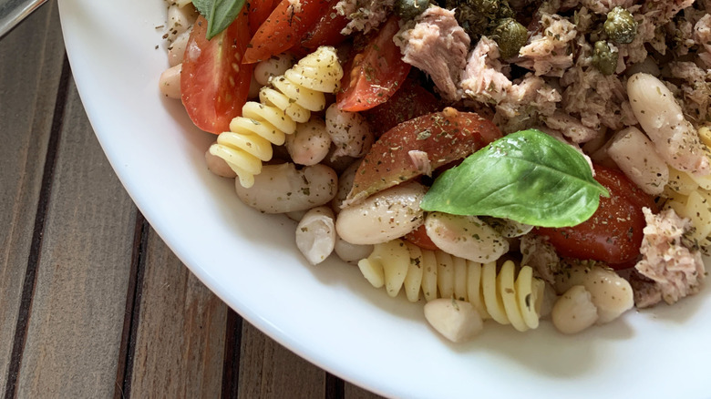 Pasta salad with sprigs of fresh herbs