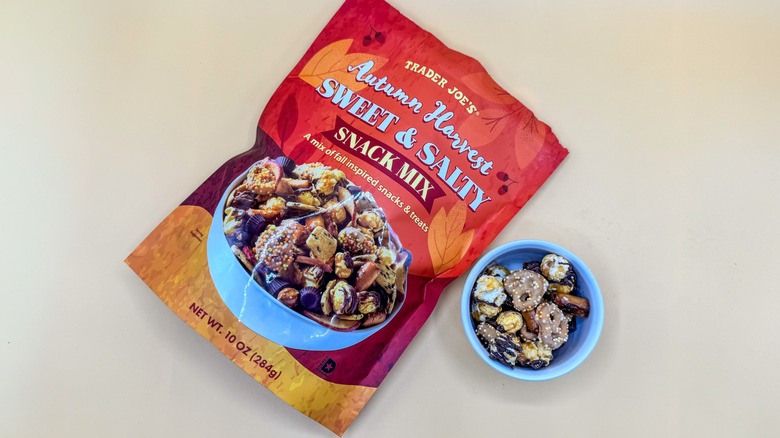 Bag of Autumn Harvest snack mix next to a filled bowl on yellow background