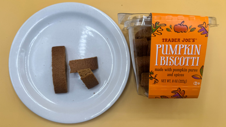 Package of Pumpkin Biscotti beside a few pieces on a plate