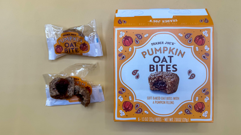 Two pieces of Pumpkin Oat Bites beside their box on a yellow surface