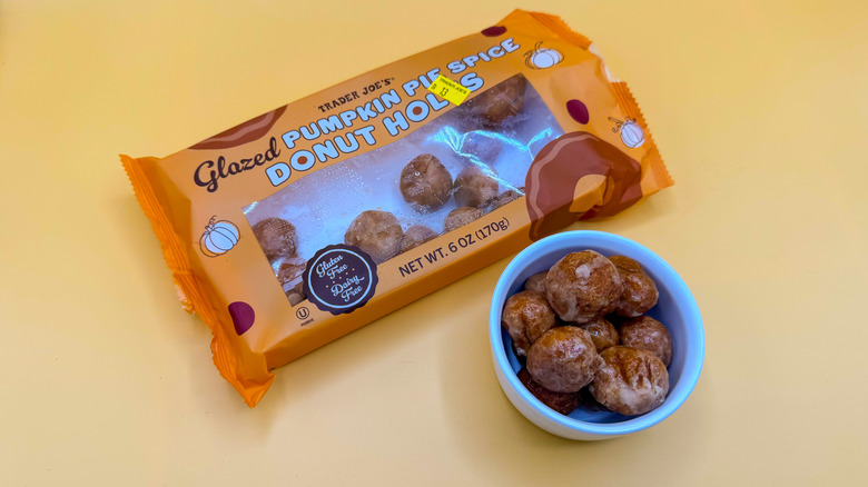 Bowl and package of Trader Joe's Pumpkin Pie Spice Donut Holes on yellow background