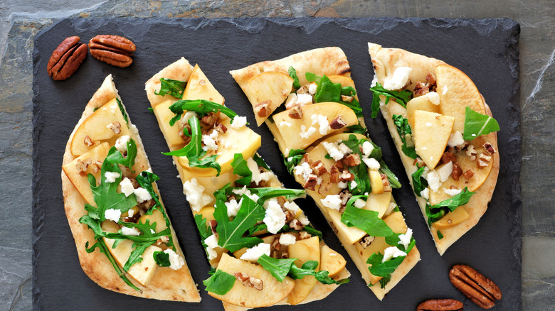 Apples on a pizza with arugula and figs