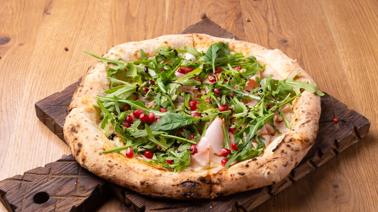 Pomeganate seeds on arugula pie
