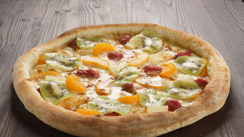 Dessert pizza with strawberries and kiwi and oranges