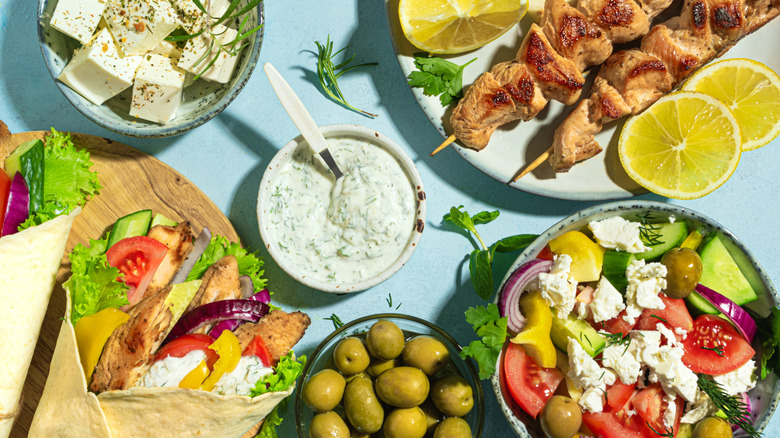A selection of Greek dishes laid out on a light blue background