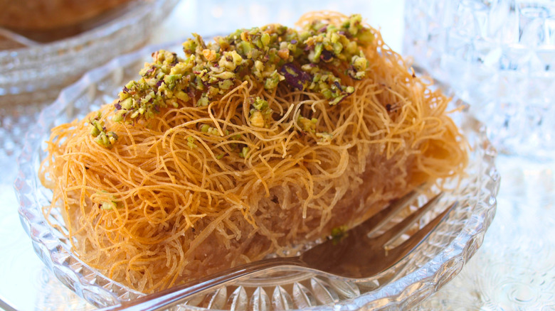 A kataifi roll garnished with chopped pistachios