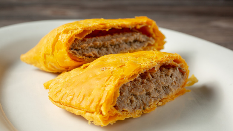 A Jamaican beef patty cut in half to reveal the inside