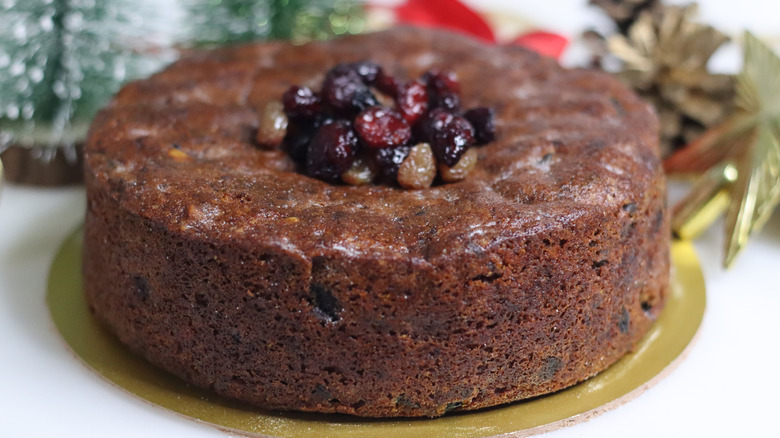 A whole rum cake garnished with soaked fruit