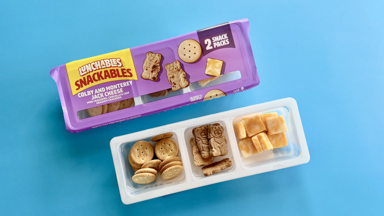 Snackables 2-pack trays with colby and monterey jack cheese on a blue surface